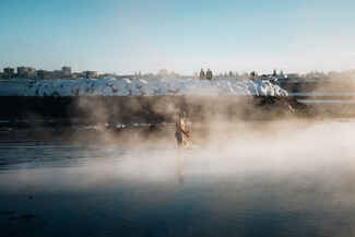 A man is seen walking into the ocean amid rising steam.